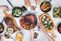 シンガポールにあるJW Marriott Hotel Singapore South Beachのテーブルいっぱいの食べ物を食べている人々のグループ