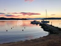 a marina with boats in the water at sunset at Villa Tranquility - Walk to the Beach with Infinity Pool in Porto Heli