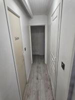 an empty hallway with two white doors and a wooden floor at Appartement meublé , 1 chambre in Magnanville