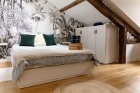a bedroom with a bed with green and white pillows at Maison et appartement attenant pour 10 personnes avec terrasse, cour et parking in Pau