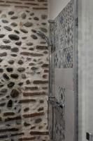 a shower in a bathroom with a stone wall at Maison et appartement attenant pour 10 personnes avec terrasse, cour et parking in Pau