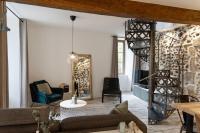 a living room with a couch and a spiral staircase at Maison et appartement attenant pour 10 personnes avec terrasse, cour et parking in Pau