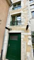 a green door on a building with two windows at Maison et appartement attenant pour 10 personnes avec terrasse, cour et parking in Pau