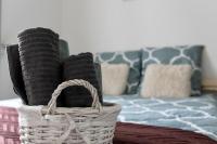 a basket sitting on top of a bed with pillows at Maison et appartement attenant pour 10 personnes avec terrasse, cour et parking in Pau