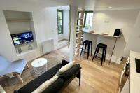 a living room with a couch and a table and a kitchen at Maison et appartement attenant pour 10 personnes avec terrasse, cour et parking in Pau