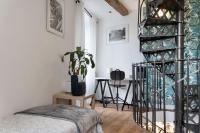 a bedroom with a spiral staircase and a table at Maison et appartement attenant pour 10 personnes avec terrasse, cour et parking in Pau