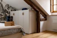 a room with a white refrigerator in a attic at Maison et appartement attenant pour 10 personnes avec terrasse, cour et parking in Pau