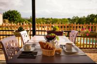 ein Tisch mit Essen und einem Korb Brot darauf in der Unterkunft L'Escale Occitane in Alzonne