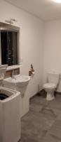 a white bathroom with a toilet and a sink at Gite de la longue fosse in Mandeville-en-Bessin