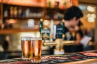 dos vasos de cerveza sentados en un bar en Panorama Hotel St Helens, en St Helens