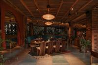 a restaurant with wooden tables and chairs in a room at Desa Potato Head Bali in Seminyak