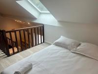 a white bed in a room with a staircase at Le 46 Magenta - Grand Duplex en hypercentre in Poitiers