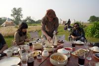 a group of people sitting around a table with food at Burhan Wilderness Camps in Bhurkīā