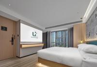 ein Hotelzimmer mit 2 Betten und einer Leinwand in der Unterkunft Lan Wan Hotel - One Free Cockt ail Per Room--Cha rgeable Airport Pick-up Service in Guangzhou