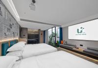 ein Hotelzimmer mit zwei Betten und einem Flachbildfernseher in der Unterkunft Lan Wan Hotel - One Free Cockt ail Per Room--Cha rgeable Airport Pick-up Service in Guangzhou