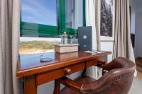 a wooden desk with a chair next to a window at Hotel Tugasa Arco de la Villa in Zahara de la Sierra