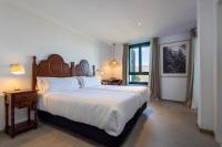 a bedroom with a large bed and a window at Hotel Tugasa Arco de la Villa in Zahara de la Sierra
