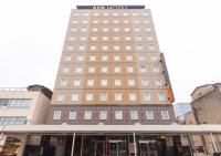 Un edificio alto con un cartel encima. en APA Hotel Niigata Furumachi, en Niigata