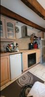 a kitchen with wooden cabinets and a white dishwasher at Maison dans un havre de paix in Saint-Julien-le-Petit