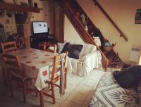 a living room with a table and a couch at Maison dans un havre de paix in Saint-Julien-le-Petit