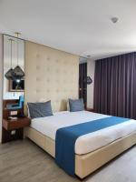 Un dormitorio con una cama grande con un cabecero grande. en Afrin Prestige Hotel, en Maputo