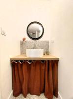 ein Bad mit einem Waschbecken und einem Spiegel in der Unterkunft Gîte-appartement RDC La Ville au Monnier in Pleurtuit