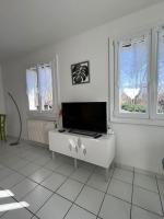 a white room with a tv and two windows at Sabot de Vénus YourHostHelper in Annecy