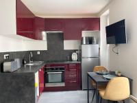 a kitchen with red cabinets and a table with chairs at Chez NAYA- Proximité Paris- Métro 8 in Alfortville