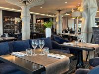 - un restaurant avec 2 tables et des chaises et des verres à vin dans l&#39;établissement La Grande Terrasse Hotel&amp;Spa La Rochelle MGallery Hotel Collection, à Châtelaillon-Plage