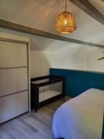 a bedroom with a bed and a lamp and a door at Maison de vacances: chez Nirina in Mortagne-sur-Sèvre