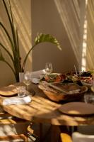 チェシメにある@before sunsetの木製テーブル(食べ物、ワイングラス付)