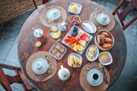 Una mesa de madera con alimentos para el desayuno y café. en Pousada Sargi&mar, en Uruçuca