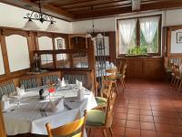 una sala da pranzo con tavolo e sedie bianchi di Hotel Restaurant Moosmühle a Dietenhofen