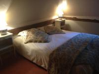 a bedroom with a bed with pillows and two lamps at Gîtes du Manoir de la Porte in Les Authieux-sur-Calonne