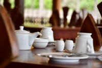 een houten tafel met witte vazen en borden erop bij Sea Way Hotel in Nilaveli