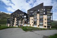 a large apartment building in the middle of a parking lot at Résidence Villaret - Studio pour 4 Personnes 194 in Les Menuires