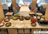 a table with plates and bowls of food on it at The Gaia Hotel - Taipei in Taipei