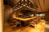 una cocina grande con una barra larga con taburetes en OND HOTEL（オンドホテル）, en Takeo