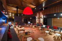 un vestíbulo con sofás, mesas y chimenea en Marmotel & Spa, en Pra-Loup