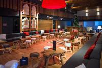 un restaurante con mesas y sillas y un árbol de Navidad en Marmotel & Spa, en Pra-Loup