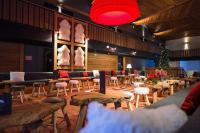 un restaurante con mesas y sillas y un árbol de Navidad en Marmotel & Spa, en Pra-Loup