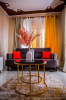 a living room with a table and a couch at The Cozy Haven Kisasi in Kampala