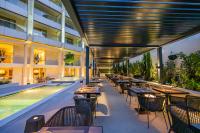een restaurant met tafels en stoelen naast een zwembad bij Divani Escape - Adults Only in Athene