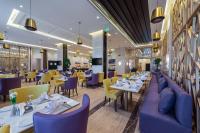 泰布克Best Western Plus Tabuk City Center的有白色桌子和蓝色椅子的餐厅