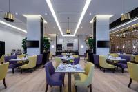 泰布克Best Western Plus Tabuk City Center的餐厅设有紫色和黄色的椅子和桌子