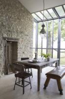 a dining room with a wooden table and chairs at Bassiviere Barn Chic in Saint-Étienne-de-Villeréal