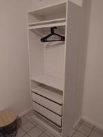 a closet with white shelves and a stool at Confortable appart 5 mins centre de valenciennes in Anzin