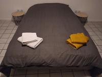 a bed with two towels sitting on top of it at Confortable appart 5 mins centre de valenciennes in Anzin
