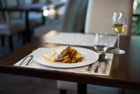 um prato de comida numa mesa com um copo de vinho em Wellness Penzion Life em Číměř