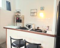 a kitchen with a counter with two stools at a bar at Le Parvis - Vue Cathédrale - Plein Centre Ville in Beauvais